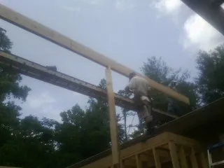 Carpenter setting a ridge beam over a new addition frame — Ice Dam Removal by Roofing Brothers in Chatsworth